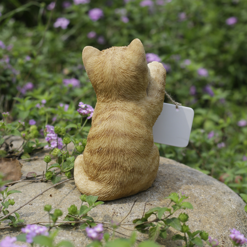 右手でボードを持つ茶トラ白猫