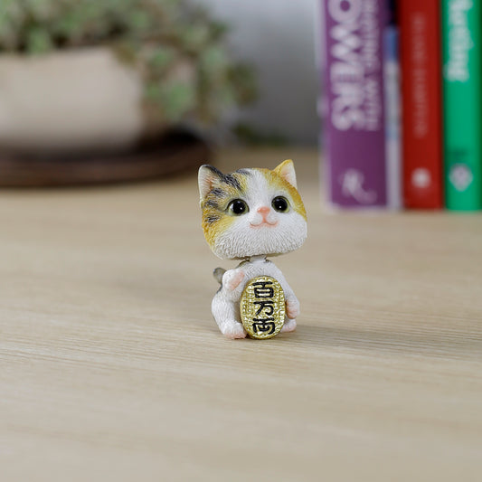 小判をかかえる首振り三毛猫
